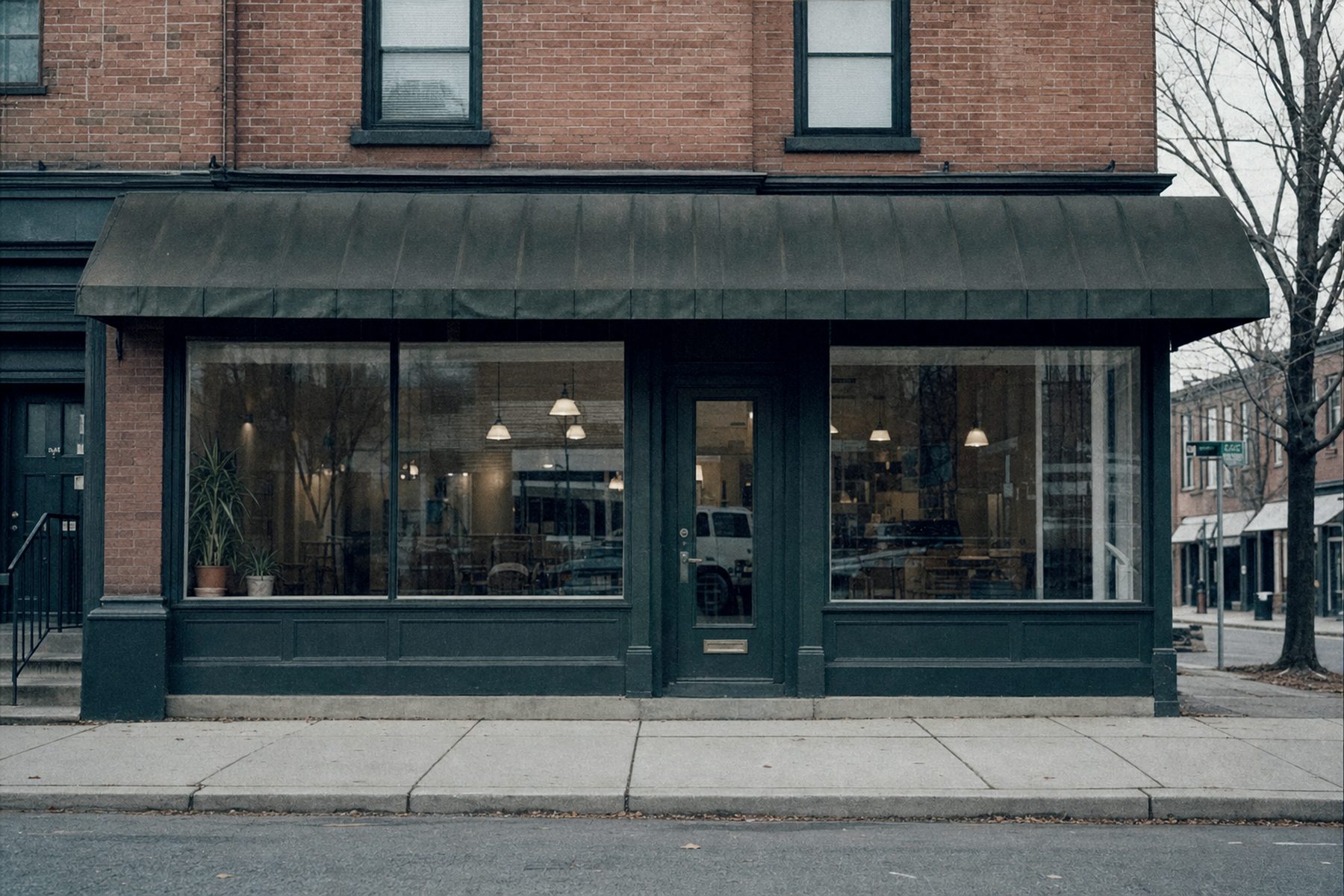 A modest independent restaurant storefront on a quiet street in flat overcast light.